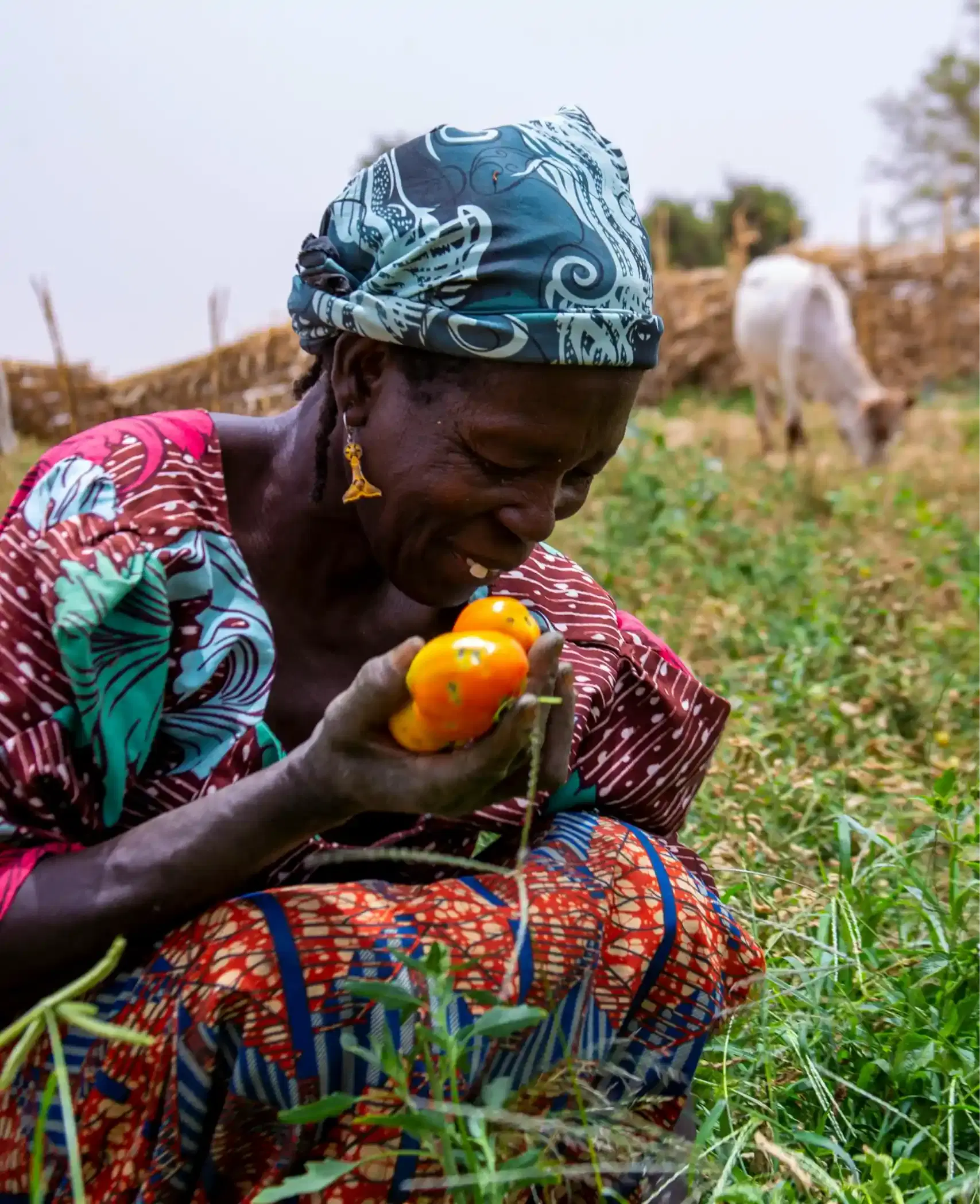 Woman smiling while holding tomatoes